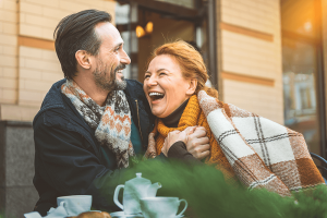 Older couple smiling together and drinking coffee.