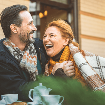 Older couple smiling together and drinking coffee.