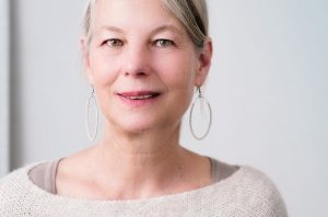 A smiling middle-aged woman with large hoop earrings.