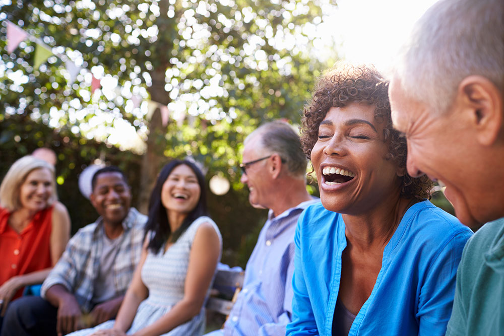 A group of friends sitting together outside and laughing