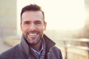 A man standing outside on a balcony smiling