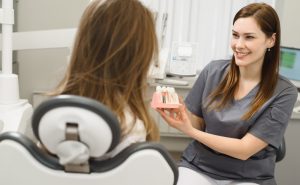 dentist showing patient a model of implants