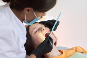 dental hygienist working on sedated patient