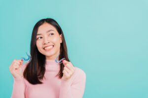girl holding clear retainers