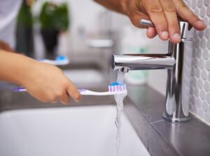 someone running toothbrush under water