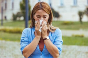 woman outside blowing her nose