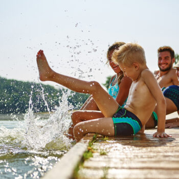 family on lake dock smiling together