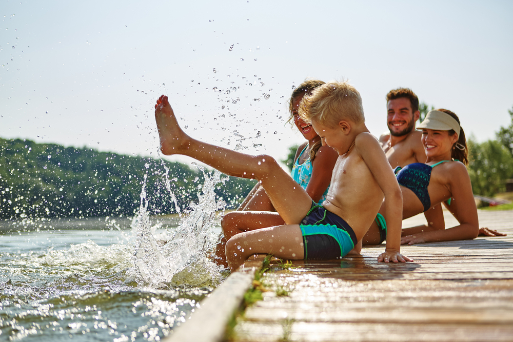 family on lake dock smiling together