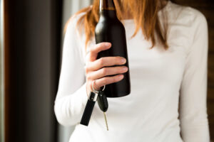 woman holding water bottle and car keys